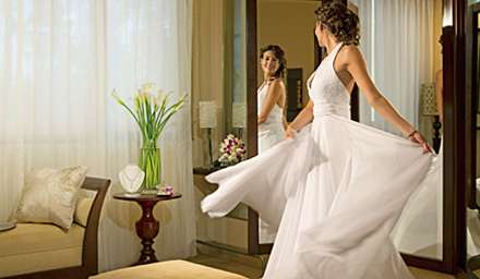 A bride spinning around in her wedding dress in a bridal suite getting ready for her destination wedding