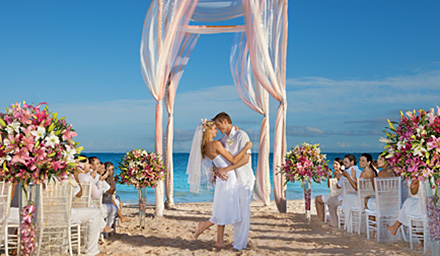 A newly married couple embracing after their wedding ceremony on tropical beach at their destination wedding