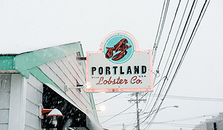 Portland Lobster Co. sign hanging from a restaurant in Maine